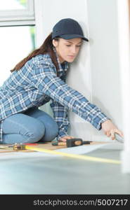 Young woman cutting flooring with stanley knife