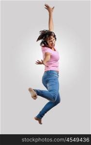 young woman dancing and jumping. pretty modern slim hip-hop style woman jumping dancing on a grey background