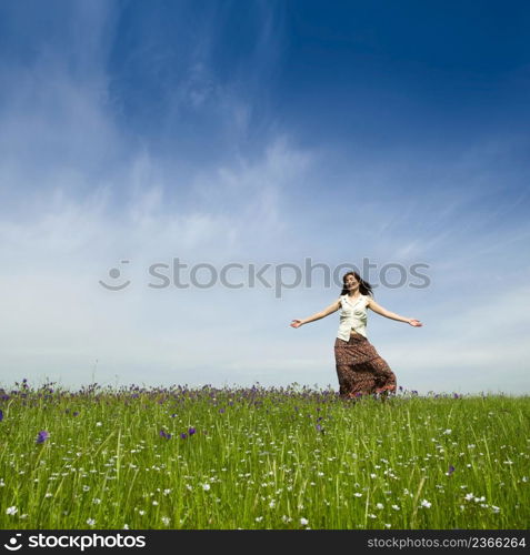 Young woman dancing on a beautiful green meadow