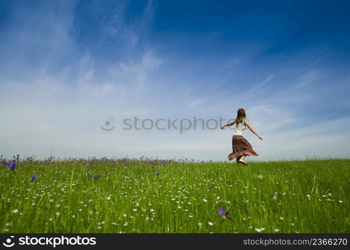 Young woman dancing on a beautiful green meadow