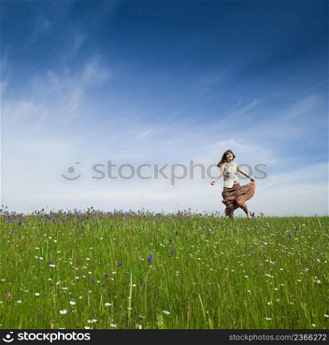 Young woman dancing on a beautiful green meadow