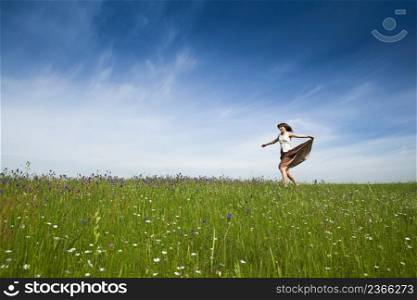 Young woman dancing on a beautiful green meadow