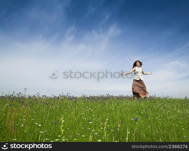 Young woman dancing on a beautiful green meadow