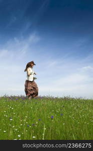 Young woman dancing on a beautiful green meadow