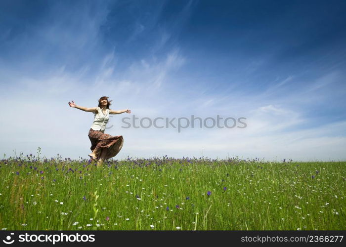 Young woman dancing on a beautiful green meadow