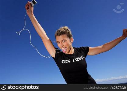 young woman dancing with mp3 player in hand