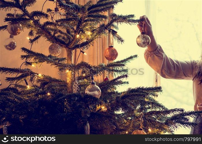 Young woman decorates a christmas tree tradition holiday beauty. Young woman decorates a christmas tree, tradition holiday