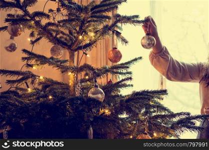 Young woman decorates a christmas tree tradition holiday beauty. Young woman decorates a christmas tree, tradition holiday
