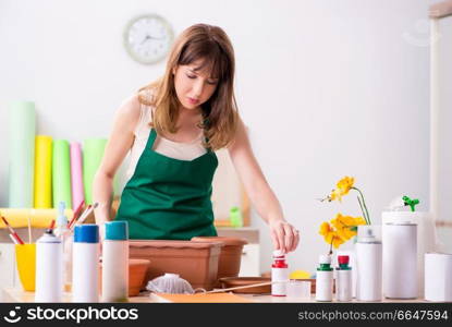 Young woman decorating pottery in workshop