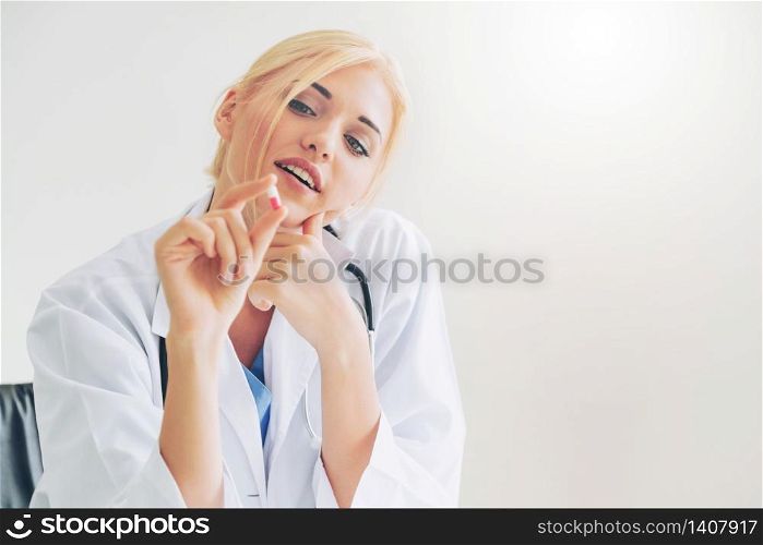 Young woman doctor holding a medicine pill in hand. Medical healthcare concept.. Young woman doctor holding a medicine pill in hand