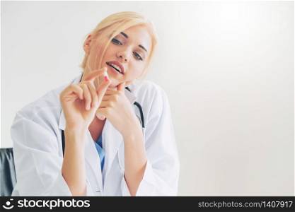 Young woman doctor holding a medicine pill in hand. Medical healthcare concept.. Young woman doctor holding a medicine pill in hand