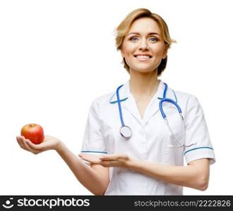 Young woman doctor isolated on white background holding apple. Woman doctor standing on white background