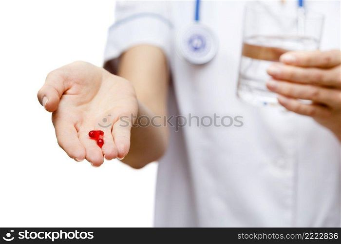 Young woman doctor isolated on white background holding pills. Woman doctor standing on white background