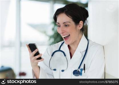 young woman doctor sitting with your phone