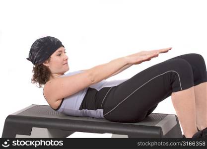 Young woman doing abdominal crunches on white background