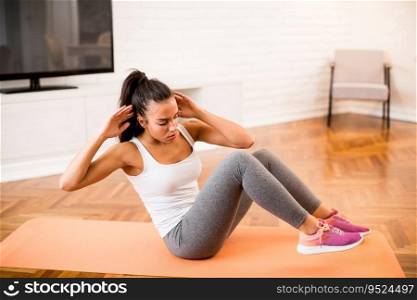Young woman doing abs morning exercise in the room