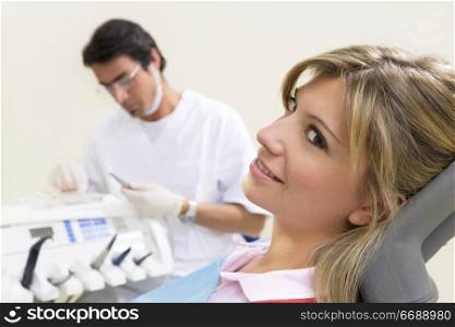 young woman doing dental checkup. Dentist in the background