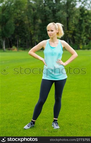 Young woman doing fitness as she is standing in the grass
