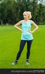 Young woman doing fitness as she is standing in the grass