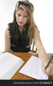 Young woman doing homework at table.