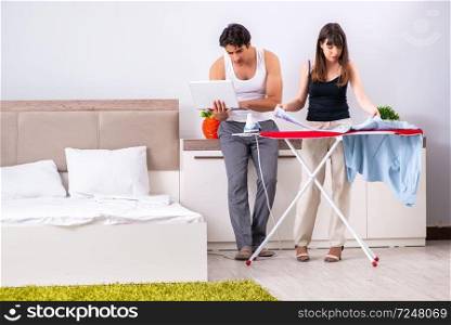 Young woman doing ironing for her husband