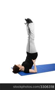 young woman doing shoulder stand. young woman exercising shoulder stand on blue mat