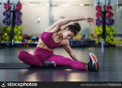 Young woman Doing Stretching Exercises on a yoga mat at the Gym. Young woman Doing Stretching Exercises on a yoga mat
