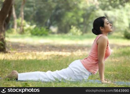 Young woman doing yoga in lawn