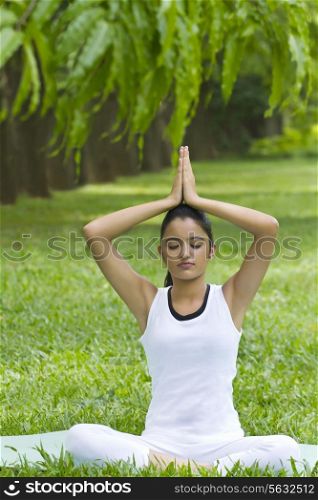 Young woman doing yoga with hands in prayer position