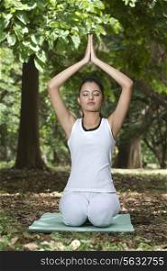 Young woman doing yoga with hands in prayer position