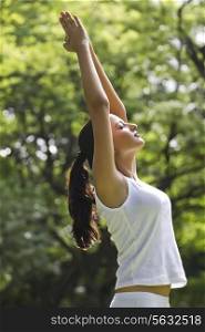 Young woman doing yoga with hands outstretched