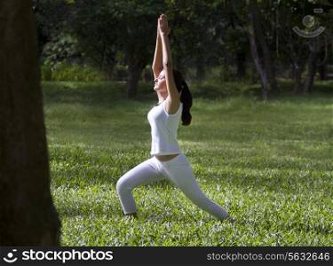 Young woman doing yoga with hands outstretched