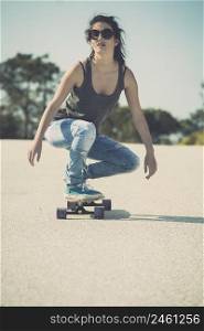 Young woman down the road with a skateboard
