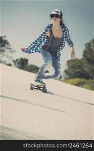 Young woman down the road with a skateboard
