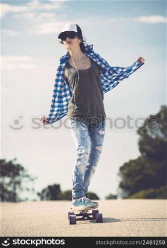 Young woman down the road with a skateboard. Skater Girl