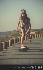 Young woman down the street with a skateboard