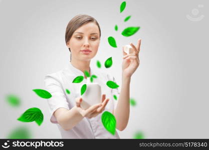 Young woman dressed in white holds a beauty product container