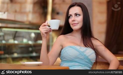 young woman drinking coffee in a cafe