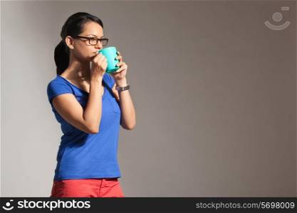 Young woman drinking from a mug of tea