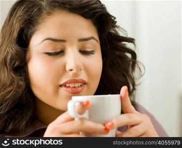Young woman drinking from cup, close up
