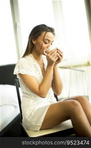 Young woman drinking morning coffee in the room