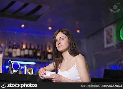 Young woman drinking tea at bar