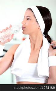 young woman drinking water after sport