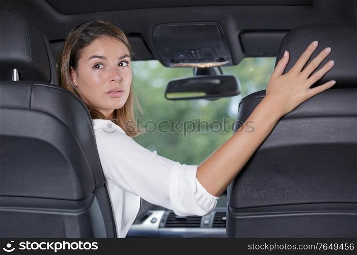 young woman driver reversing car