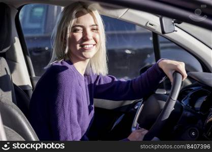Young woman driver sitting in car, driving.