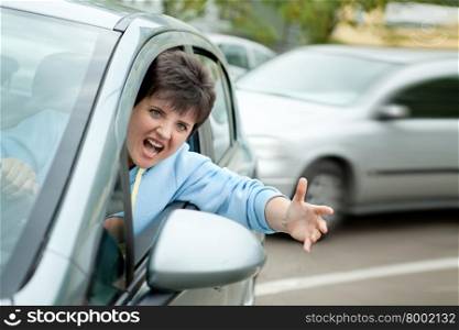 Young Woman Driver Yelling and Shaking her Wrist out Car Window.