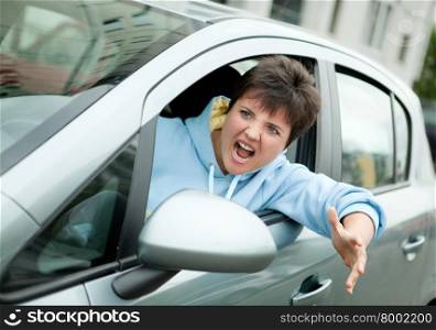 Young Woman Driver Yelling and Shaking her Wrist out Car Window.