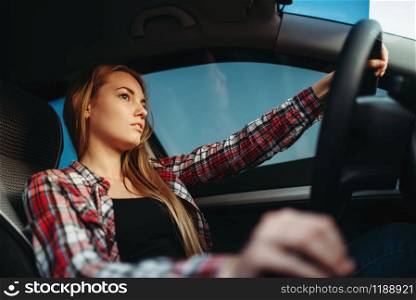 Young woman drives a car. Female person in vehicle, driving automobile concept. Young woman drives a car