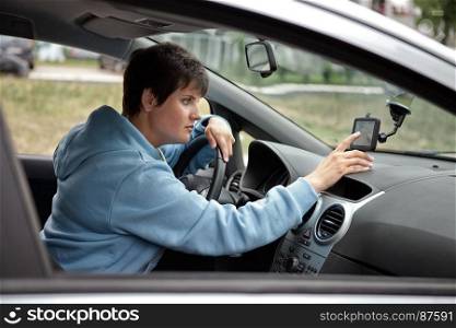Young Woman Drives the Car and Looking for a Way to Navigator in the Road