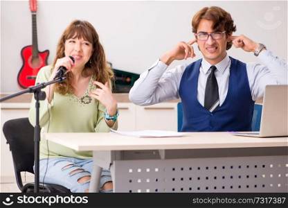 Young woman during music lesson with male teacher